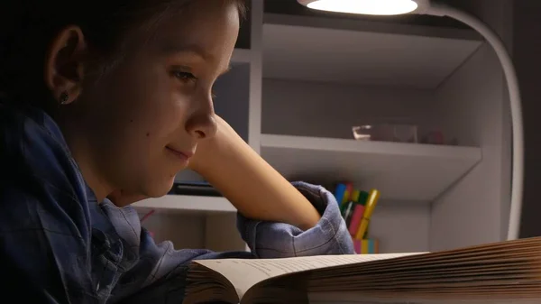 Criança que lê na noite, menina da escola que estuda no escuro, aprendizagem da criança, lição de casa — Fotografia de Stock