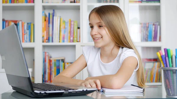 Kid using Laptop Studying in Video Conferencing, Child Learning, Writing in Library, Schoolgirl Chatting with Teacher from Home Coronavirus Pandemic Crisis, Children Homeschooling, Online Education — Stock Fotó