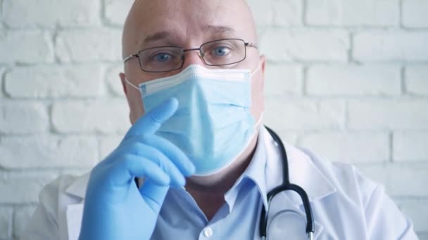 Врач носит защитную маску для лица в связи с кризисом вспышки коронавируса, медицинское лицо с защитным оборудованием — стоковое видео