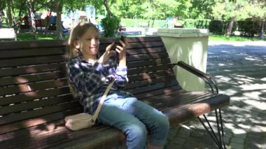 Parktaki oyun parkında internet gezen çocuk Bench 'te oturan kız, Park' taki çocuk.