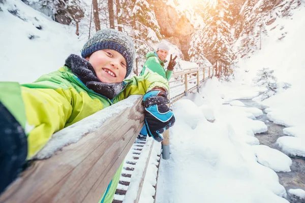 少年は雪の山のカヌーで父親と一緒に自撮り写真を撮る — ストック写真