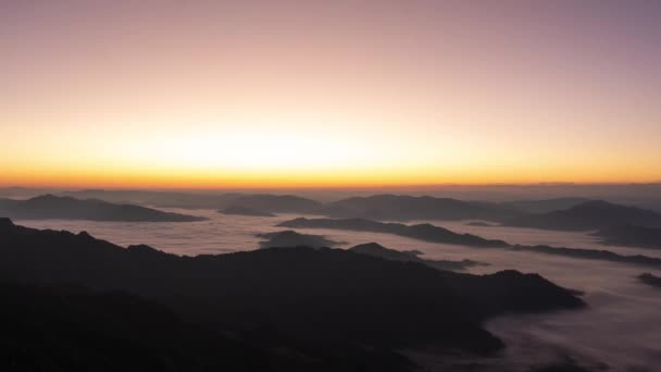 美しい景色雲の動きや霧を持つ山の上のタイムラプス日の出ビュー 天の丘の高いピークに太陽の光とカラフルなオレンジ色の空 — ストック動画