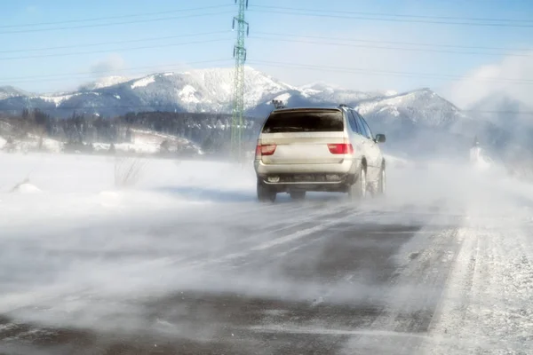 Автомобиль на дороге в снежную метель — стоковое фото