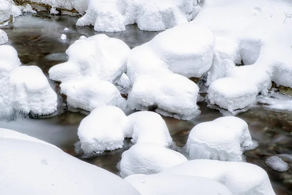 凍った水が雪に覆われた森林を温泉します。. — ストック写真