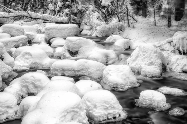 Lange Belichtung des gefrorenen Baches im verschneiten Wald. — Stockfoto