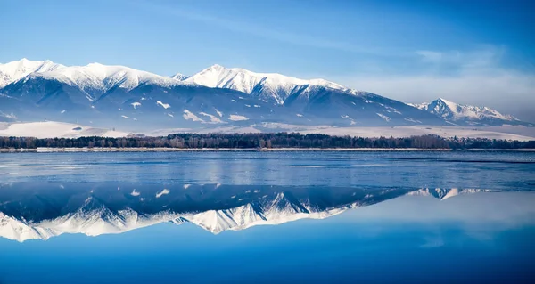 Reflexão sobre o lago Liptovska Mara coberto de gelo e Tatras baixos — Fotografia de Stock