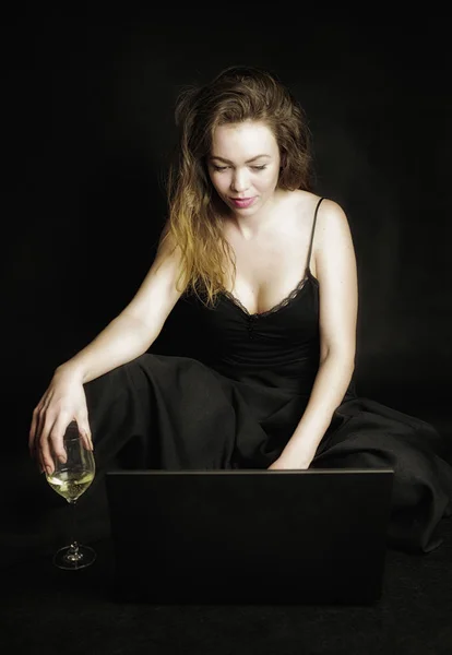Rothaarige Mädchen mit Laptop und einem Glas Wein — Stockfoto
