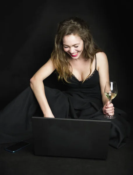 Rothaarige Mädchen mit Laptop und einem Glas Wein — Stockfoto