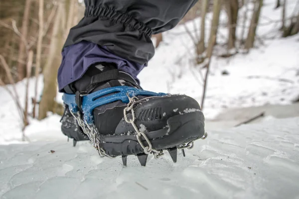 Crampons on black hiking boots