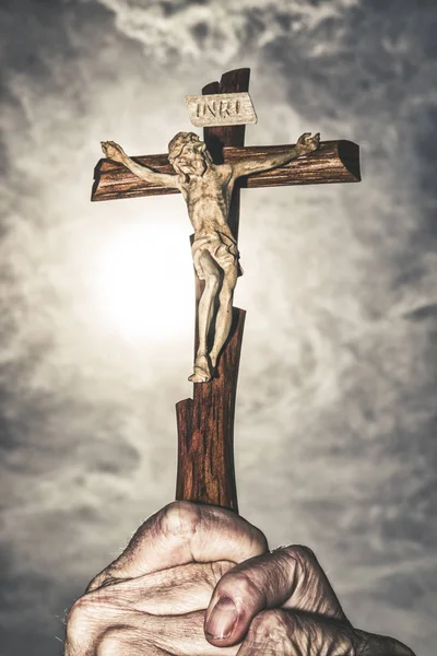 Cross in hands and dark sky — Stock Photo, Image