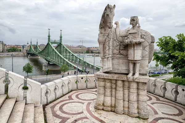 Statue in Gellert Hill und Freiheitsbrücke im Hintergrund in Budape — Stockfoto