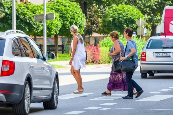 Fußgänger überquert Straße auf Zebrastreifen. — Stockfoto