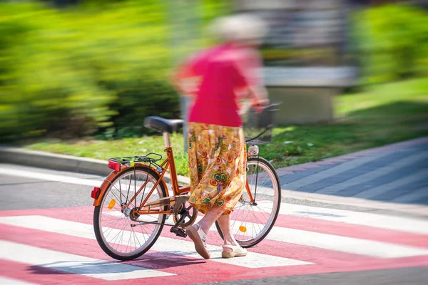Yaya geçidi ile bisiklet üzerinde bir yol geçiş kadın — Stok fotoğraf
