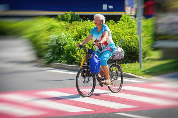 Kadın bir yol üzerinde yaya geçidi bisikletle geçiş. — Stok fotoğraf