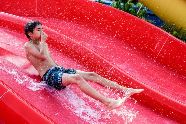 Niño deslizándose en un tobogán de agua — Foto de Stock