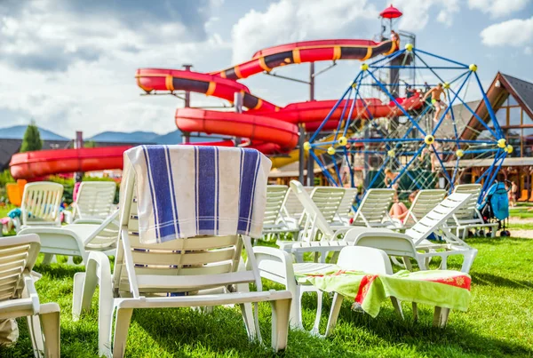 Empty lounger and water slide in aquapark — Stock Photo, Image