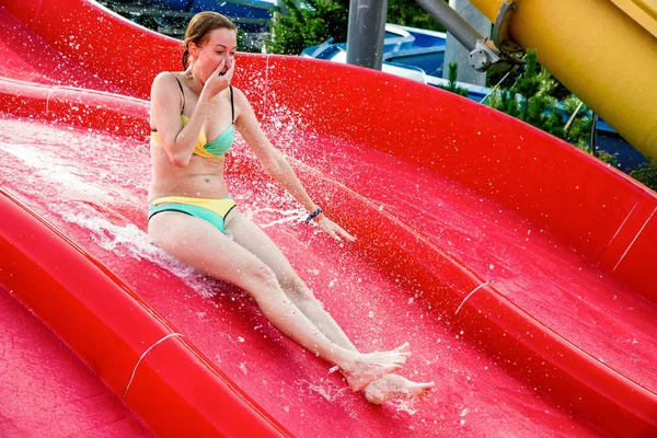 Mujer deslizándose en un tobogán de agua — Foto de Stock