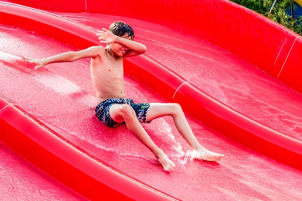 水スライドの摺動の少年 — ストック写真