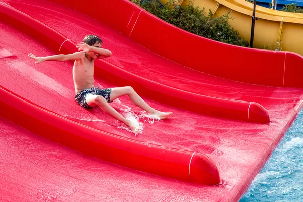 水スライドの摺動の少年 — ストック写真