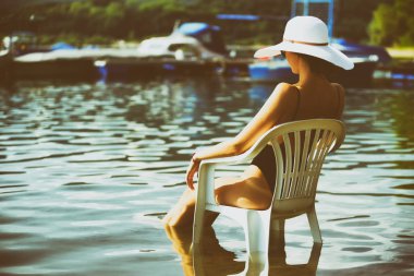 Su sandalyede oturup..... sunhat kadınla