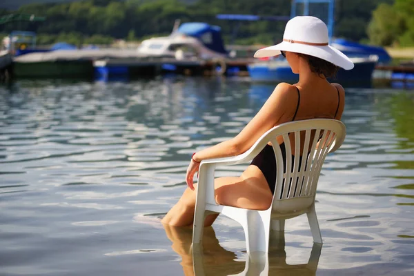 Su sandalyede oturup..... sunhat kadınla