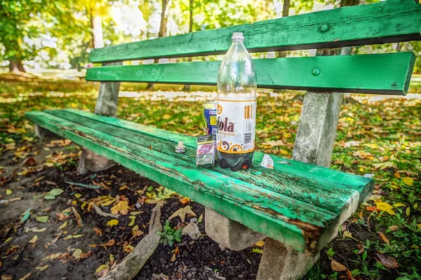 Beschadigde bankje in herfst park — Stockfoto