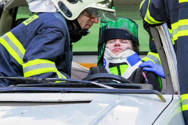 Firemans and injured passenger in  crashed car — Stock Photo, Image