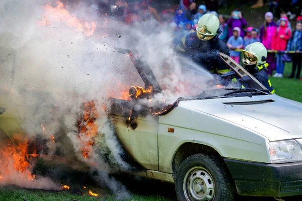 Firemans y coche en llamas — Foto de Stock