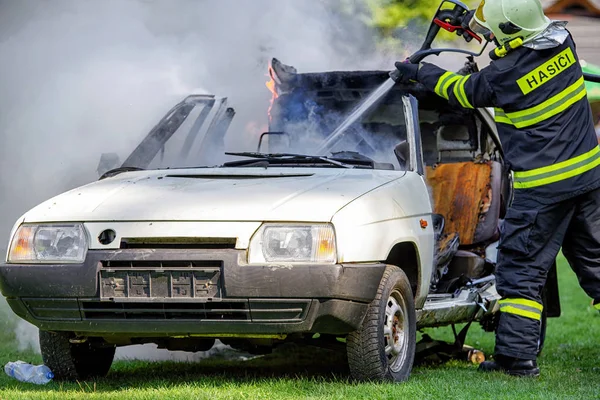 Strażak i płonącego samochodu — Zdjęcie stockowe