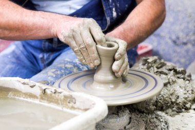 Çanak çömlek çarkı ve eller Potter