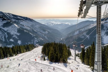 View from cableway on slope and skiers in resort Chopok Juh, Slo
