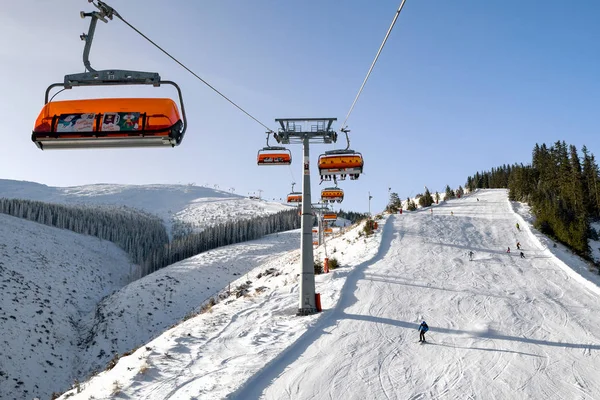 Skiers on slope in and ski lift chair at resort Jasna, Slovakia — Stok fotoğraf