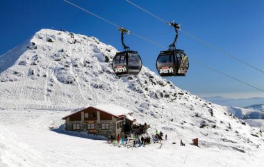 Jasna, Slovakya - 13 Mart: Kayak merkezi Jasna 'da modern kablo - 13 Mart 2014 tarihinde Jasna' da kayakçılarla alçak Tatras dağları ve kır evi