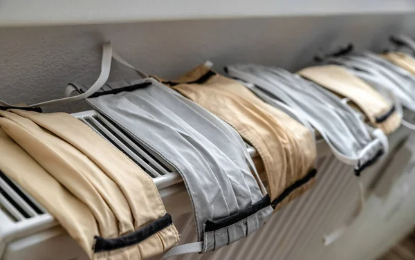 Many Protective Face Masks Drying Radiator — Stock Photo, Image