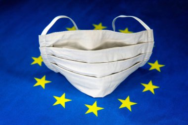 Koruyucu maske ve Avrupa Birliği bayrağıyla yüzleş