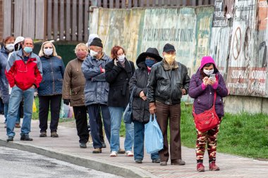 RUZOMBEROK, SLOVAKIA - 14 Nisan: Koronavirüs COVID-19 'a karşı sosyal kısıtlamalar nedeniyle maskeli insanlar bekliyor