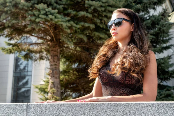 Brünettes Mädchen Mit Lockigem Haar Blickt Durch Eine Sonnenbrille — Stockfoto
