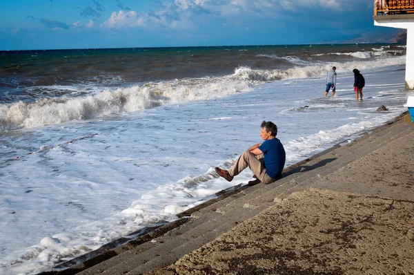 İnsanlar deniz kıyısında yürür. Köy Denizi, Kırım, Ukrayna. 15 Eylül 2013. Fırtınadan sonra deniz.
