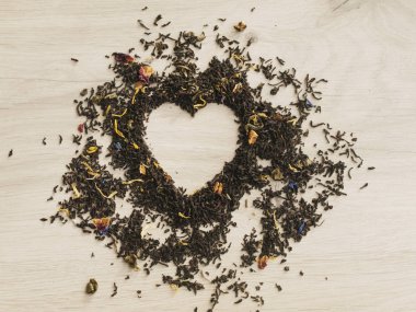 Çay kavramı. Ahşap gri masada bir kalp şeklinde çiçek kuru çay. Sevgililer günü. Aşık. Üst görünüm. Boşluk Kopyala