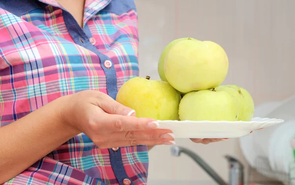 Mulher segura prato com maçãs verdes frescas — Fotografia de Stock