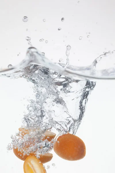 Kumquat dropped into the water — Stock Photo, Image