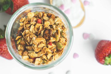 Üst manzara cam temiz şişe içinde sağlıklı granola fotokopi alanı ve arka planda taze çilek.