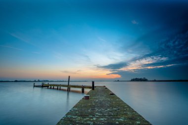 Koyu mavi alacakaranlıkta sakin bir göl üzerinde