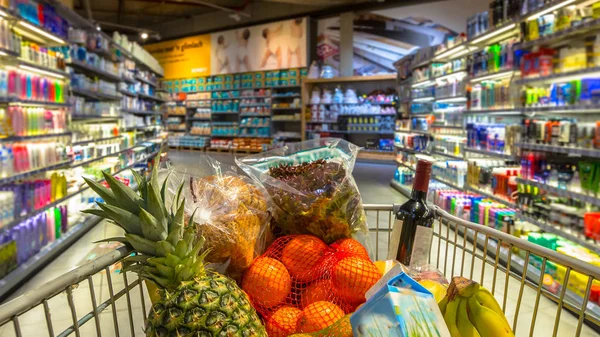 Carro en el supermercado con productos alimenticios — Foto de Stock