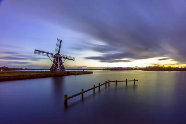 Mulino a vento in legno sotto esposizione lunga tramonto — Foto Stock