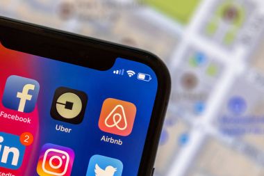 Hareket eden telefon ile sokak haritası arka plan üzerinde Airbnb uygulaması