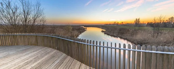 Wooden balustrade sunset over swamp — Stock Photo, Image