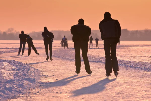 Patinadores de gelo sob o pôr do sol — Fotografia de Stock