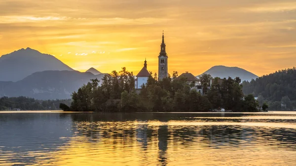 Den berömda ön i Lake bled med kyrkan under orange morgonhimlen — Stockfoto