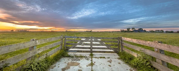 Houten hek in zuivel landbouwgrond landschap — Stockfoto